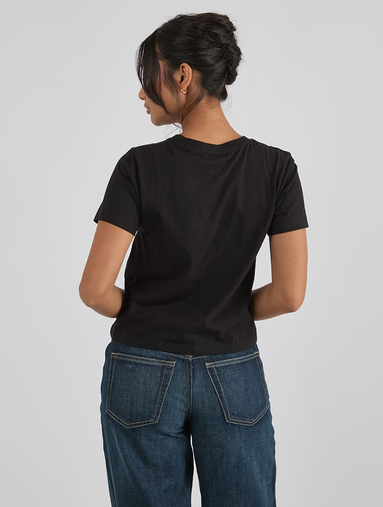 Disney Tangled Glowing Flower Baby T-Shirt In Black Tops & T-Shirts Skinnydip London